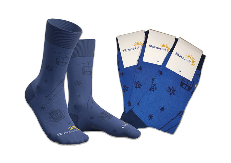 Blue Filzmoos socks with ski lift, ski and snowflake motifs on a light background. | © Bergbahnen Filzmoos GmbH