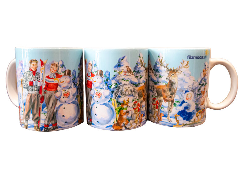 Ceramic mug with winter Filzmoos scene, snowman, stag and traditional illustrated figures. | © Bergbahnen Filzmoos GmbH
