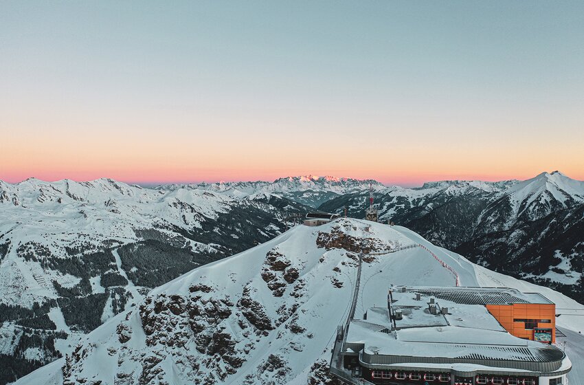 Panoramic view with snowy mountains, summit station and pink sunrise sky | © Gasteinertal Tourismus GmbH
