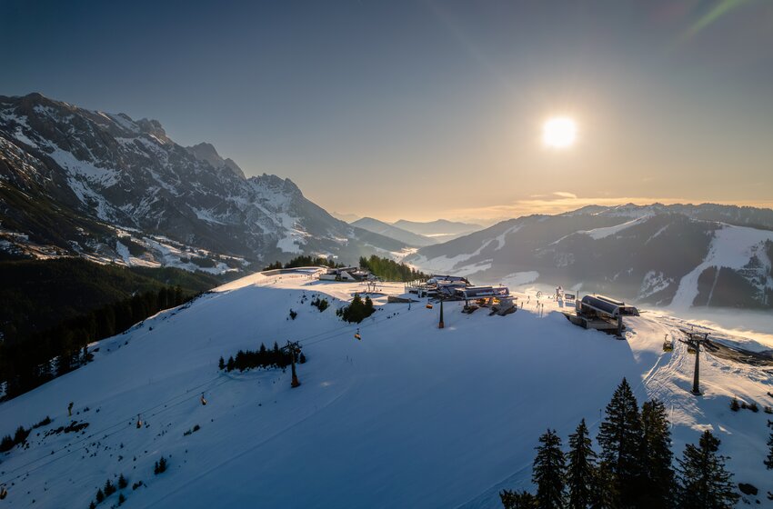 Snow-covered ski area at Hochkönig with lifts, gondolas and mountain station in bright morning sunlight | © Hochkönig Bergbahnen GmbH