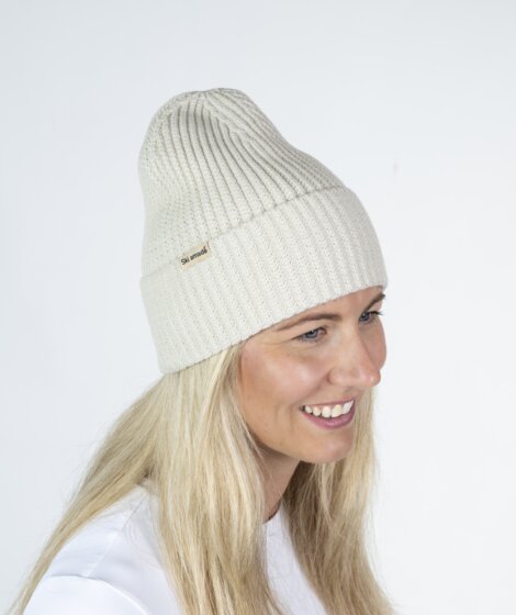 Woman in cream white Ski amadé beanie and white shirt against bright backdrop | © Ski amadé GmbH
