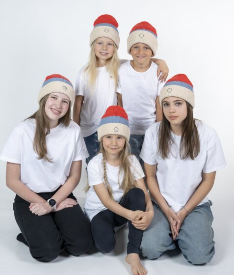 Five kids in red Mountain Vibe Ski amadé beanies and white shirts in photo studio | © Ski amadé GmbH
