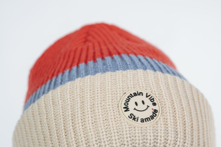 Beige, red and blue beanie with round Mountain Vibe patch and Ski amadé logo | © Ski amadé GmbH