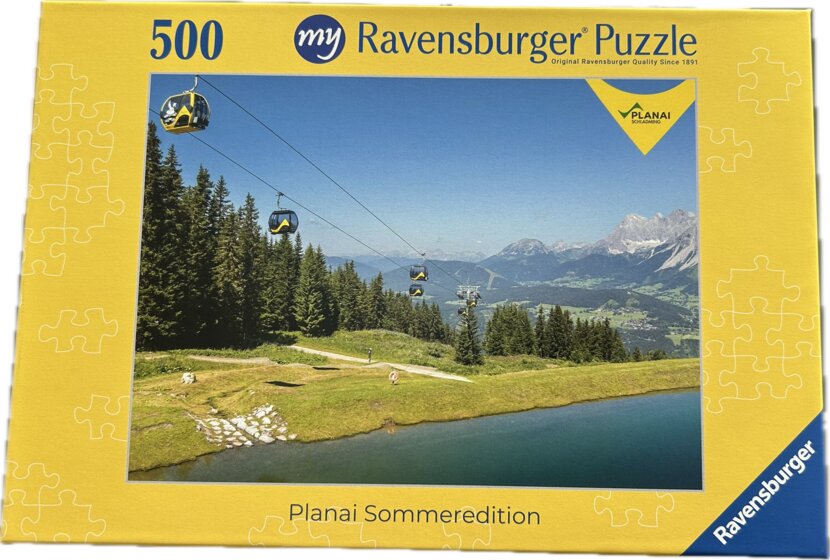 Puzzle box shows gondola lift over green meadows with reservoir, forest and Alps in summer, 500 pieces | © Planai-Hochwurzen-Bahnen GmbH