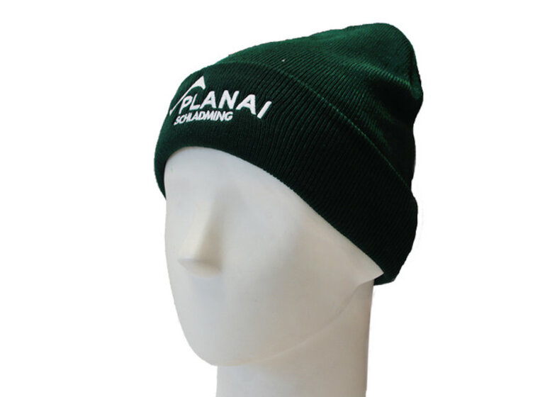 Green knit beanie with white Planai lettering and cuff, shown side view on white mannequin head | © Planai-Hochwurzen-Bahnen GmbH