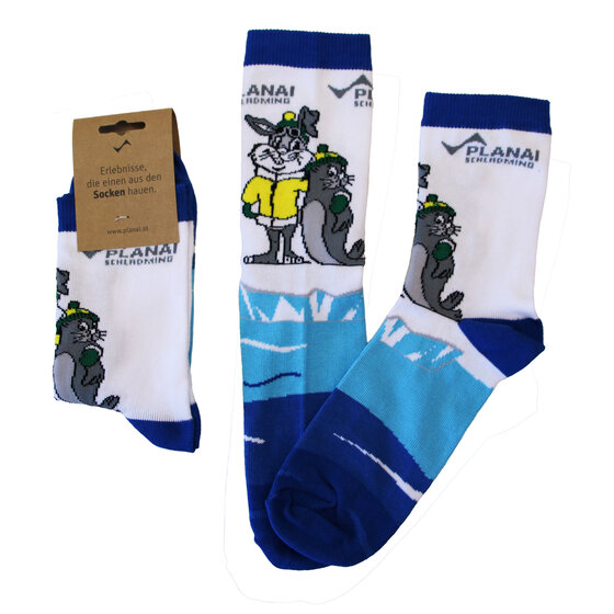 Three white kids’ socks with blue accents, showing bunny in yellow jacket and grey seal with green cap | © Planai-Hochwurzen-Bahnen GmbH