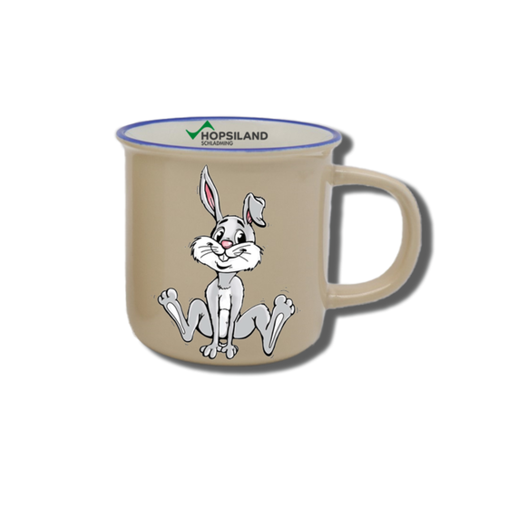 Beige kids’ mug with seated Hopsi bunny, blue rim and Hopsiland logo printed on the inside | © Planai-Hochwurzen-Bahnen GmbH