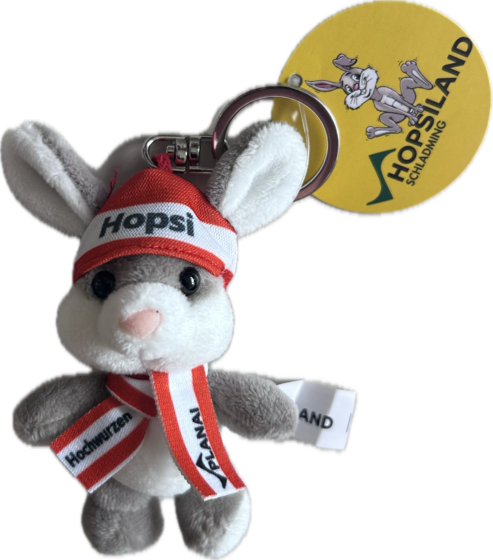 Hopsi plush bunny keyring with hat, scarf and HopsiLand tag on a transparent background for children. | © Planai Hochwurzen Bahnen GmbH